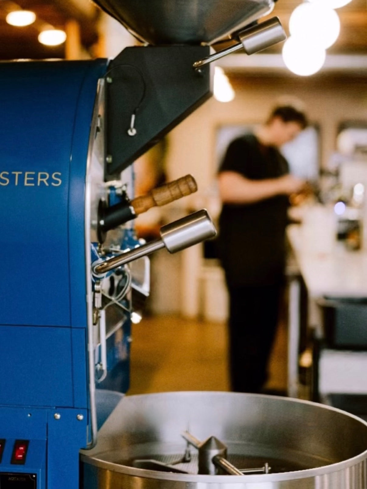 Ladder roaster at the Monroe cafe with a barista in the background steaming milk.